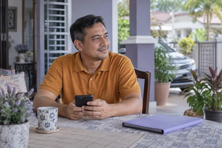 Pelanggan berpolo amber bertelefon di meja dengan folder tertutup